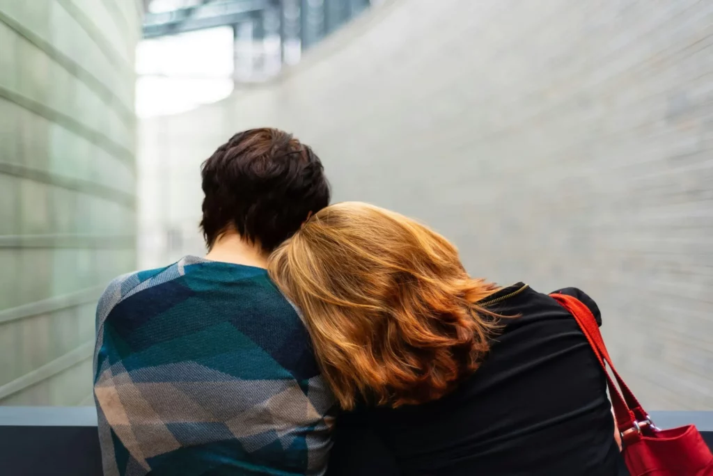 Femme posant sa tête sur l'épaule de son proche pour réconfort et soutien.